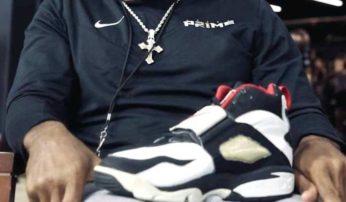 Deion Sanders holding a Diamond Turf shoe