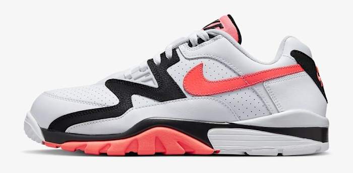 Side view of a white, orange, and black Nike shoe.