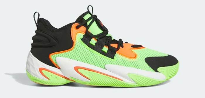 Side view of a green, orange, and black adidas shoe.