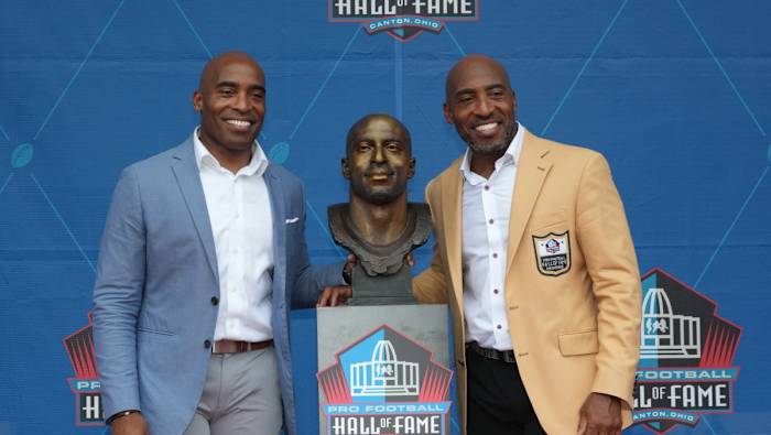 Tampa Bay Buccaneers former cornerback Ronde Barber (right) poses with his bust and his brother Tiki Barber during the 2023 Pro Football Hall of Fame Enshrinement at Tom Benson Hall of Fame Stadium.