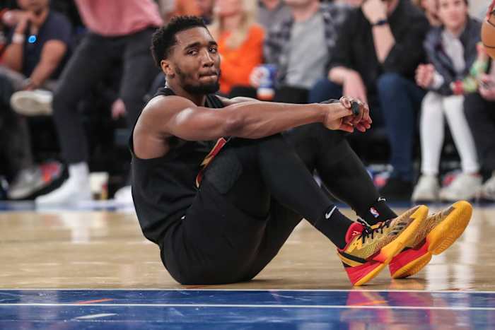 Cleveland Cavaliers guard Donovan Mitchell sits on the court after a foul.