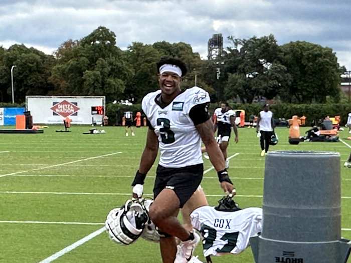 Nolan Smith carries Fletcher Cox's pads following a training camp practice