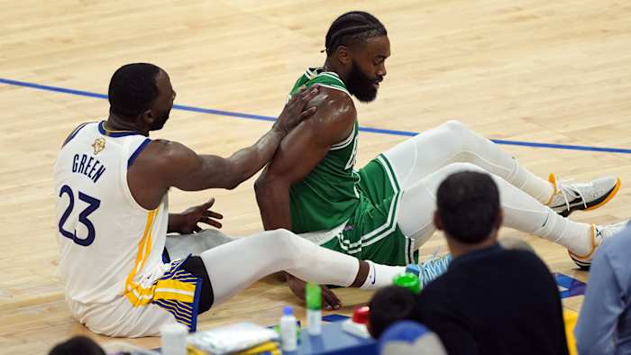 Boston Celtics guard Jaylen Brown (7) and Golden State Warriors forward Draymond Green (23) on the floor after a collision in the second half during game two of the 2022 NBA Finals.