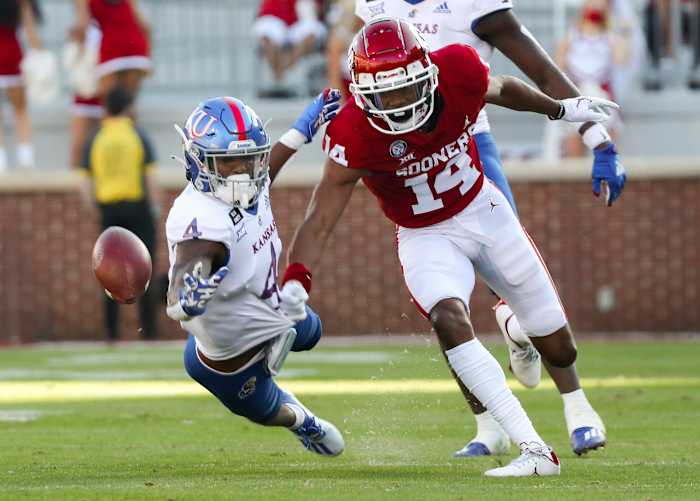 Oklahoma Sooners wide receiver Charleston Rambo (14) and Kansas Jayhawks cornerback Elijah Jones (4) go for the ball during the first half at Gaylord Family-Oklahoma Memorial Stadium.