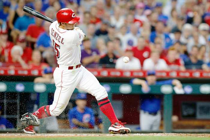 Cincinnati Reds center fielder Nick Senzel (15) knocks the glove off of the hand of Chicago Cubs catcher Jonathan Lucroy (25) on a swing in the third inning of the MLB National League game between the Cincinnati Reds and the Chicago Cubs at Great American Ball Park in downtown Cincinnati on Thursday, Aug. 8, 2019. The game was tied after three innings.
