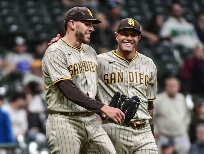 Joe Musgrove and Manny Machado embrace after chasing a foul ball against the Milwaukee Brewers.