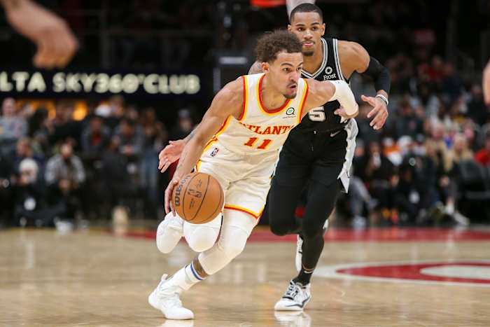 Trae Young dribbles past Dejounte Murray.