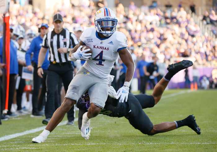 Nov 20, 2021; Fort Worth, Texas, USA; Kansas Jayhawks running back Devin Neal (4) turns the corner on TCU Horned Frogs linebacker Jamoi Hodge (6) during the first half at Amon G. Carter Stadium. Mandatory Credit: Raymond Carlin III-USA TODAY Sports