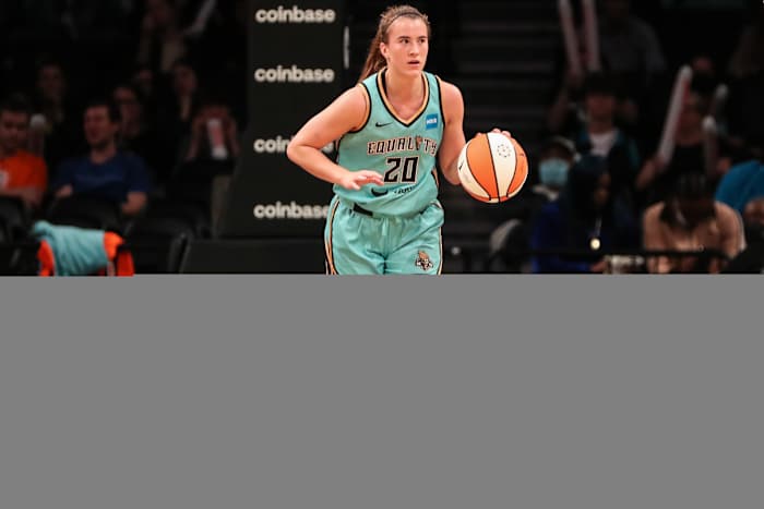 Sabrina Ionescu dribbles the ball.