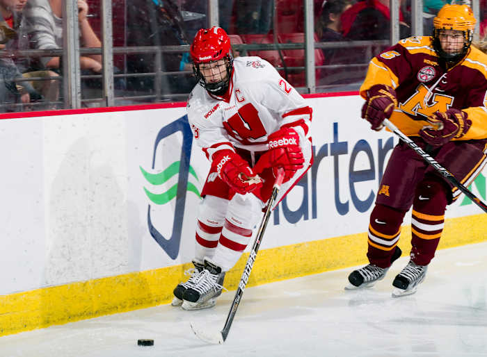 Women's hockey star Hilary Knight skating maneuvering down the ice against Minnesota
