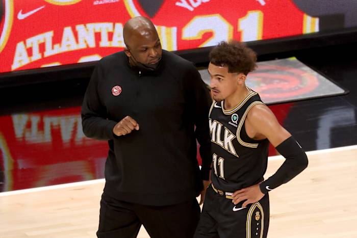 Hawks head coach Nate McMillan speaking with Trae Young.