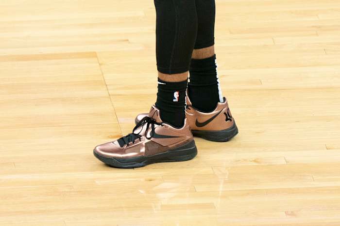 View of copper and black Nike KD shoes.