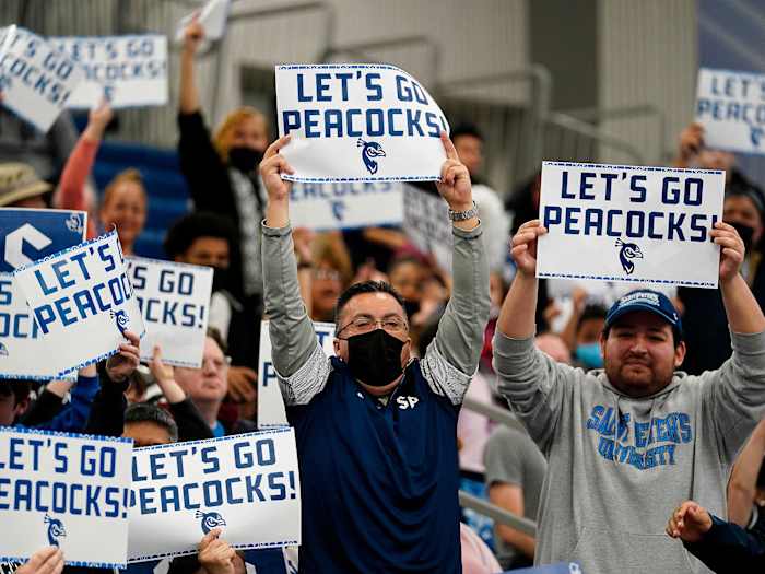 Saint Peter’s fans hold up “Let’s Go Peacocks” signs