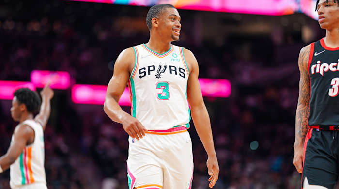 Spurs forward Keldon Johnson (3) smiles as he looks on in the second half of a game against the Trail Blazers.