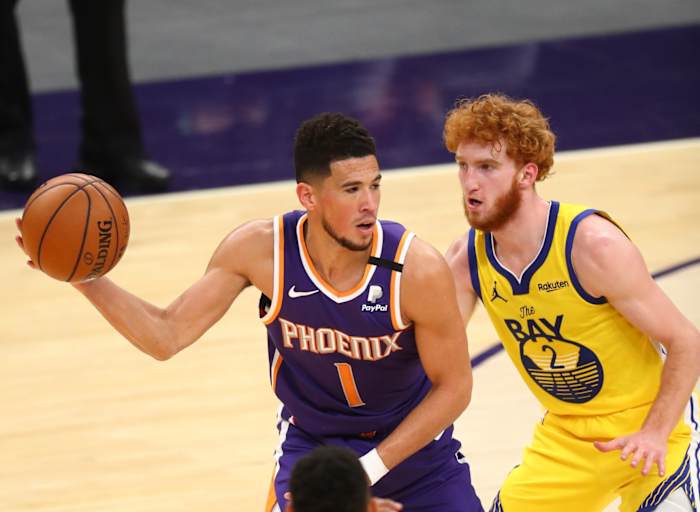Mar 4, 2021; Phoenix, Arizona, USA; Phoenix Suns guard Devin Booker (1) against Golden State Warriors guard Nico Mannion (2) at Phoenix Suns Arena. Mandatory Credit: Mark J. Rebilas-USA TODAY Sports