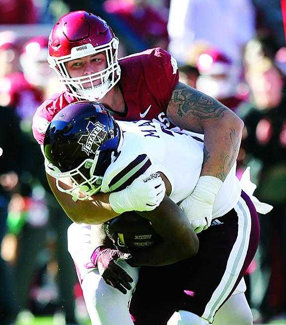 Arkansas Razorbacks defensive lineman John Ridgeway tackles Mississippi State Bulldogs running back Jo'quavious Marks during the first quarter at Donald W. Reynolds Razorback Stadium.