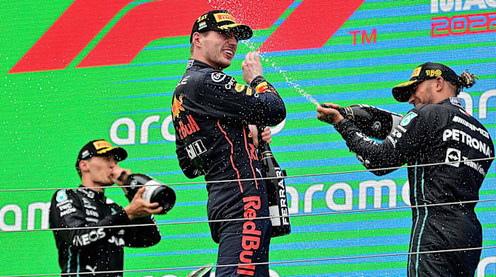 George Russell, Max Verstappen and Lewis Hamilton celebrating on podium after the Hungarian Grand Prix.