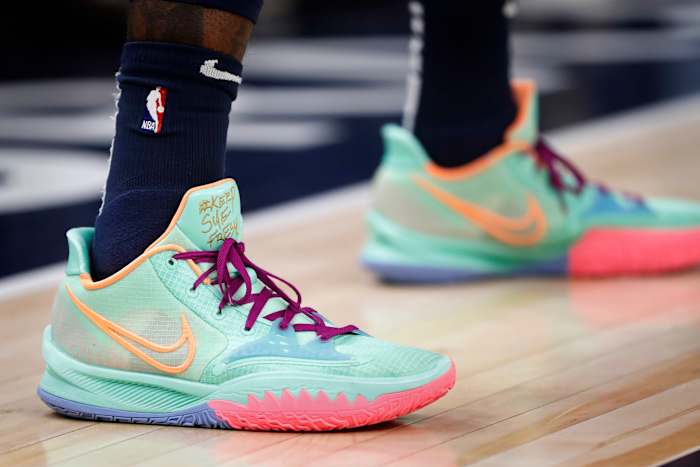 View of teal and pink Nike Kyrie Low 4 sneakers.