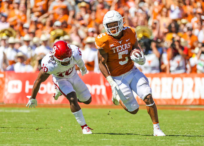 Oct 9, 2021; Dallas, Texas, USA; Texas Longhorns running back Bijan Robinson (5) runs with the ball as Oklahoma Sooners safety Pat Fields (10) defends during the game at the Cotton Bowl.