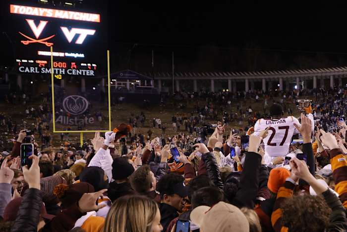 Virginia Tech Hokies defensive back Armani Chatman (27) celebrates with teammates and fans while holding the Commonwealth Cup after the Hokies' game against the Virginia Cavaliers at Scott Stadium.