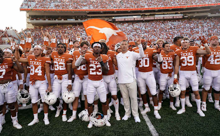 Texas football team salutes fans at end of game.