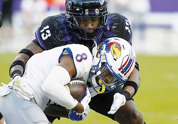 TCU's Dee Winters tackles Kansas receiver Kwamie Lassiter.