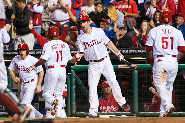 Starting pitcher Cliff Lee congratulates shortstop Jimmy Rollins as he returns to the dugout.