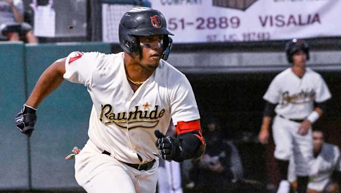 Deyvison De Los Santos runs out of the batter's box after putting a ball in play.