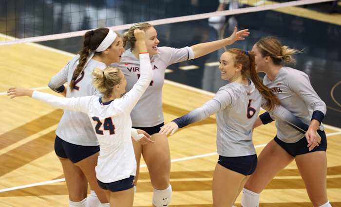 The Virginia volleyball team celebrates after scoring a point.