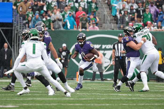 Sep 11, 2022; East Rutherford, New Jersey, USA; Baltimore Ravens quarterback Lamar Jackson (8) carries the ball as New York Jets cornerback Sauce Gardner (1) defends during the first half at MetLife Stadium. Mandatory Credit: Vincent Carchietta-USA TODAY Sports