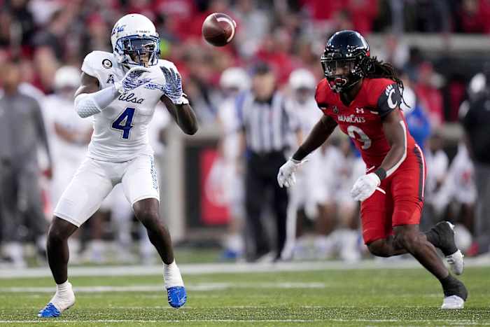 Tulsa receiver Josh Johnson (4) catches a pass as Cincinnati cornerback Arquon Bush (9) defends in the fourth quarter of the Bearcats' 28-20 win on Nov. 6. Syndication The Enquirer