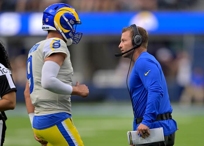 Los Angeles Rams quarterback Matthew Stafford and coach Sean McVay talk on the sidelines during a game.
