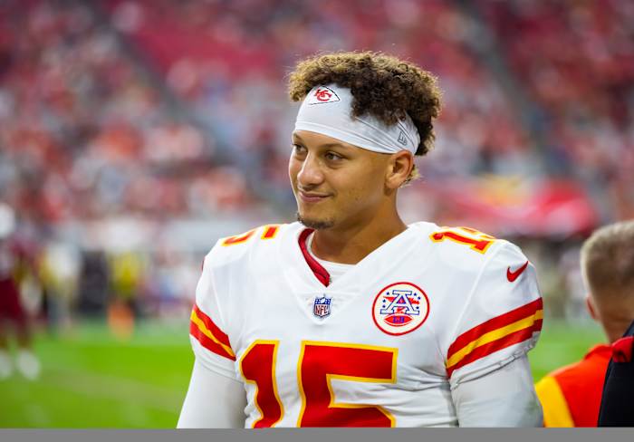 Chiefs quarterback Patrick Mahomes smiles on the sidelines of a game.