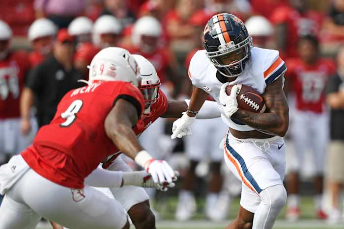 Virginia Cavaliers wide receiver Dontayvion Wicks (3) runs the ball against Louisville Cardinals linebacker C.J. Avery (9) during the first quarter at Cardinal Stadium.