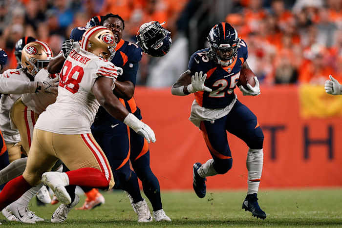 Denver Broncos running back Melvin Gordon III (25) runs the ball as offensive tackle Cameron Fleming (73) loses his helmet defending against San Francisco 49ers defensive tackle Hassan Ridgeway (98) in the third quarter at Empower Field at Mile High.