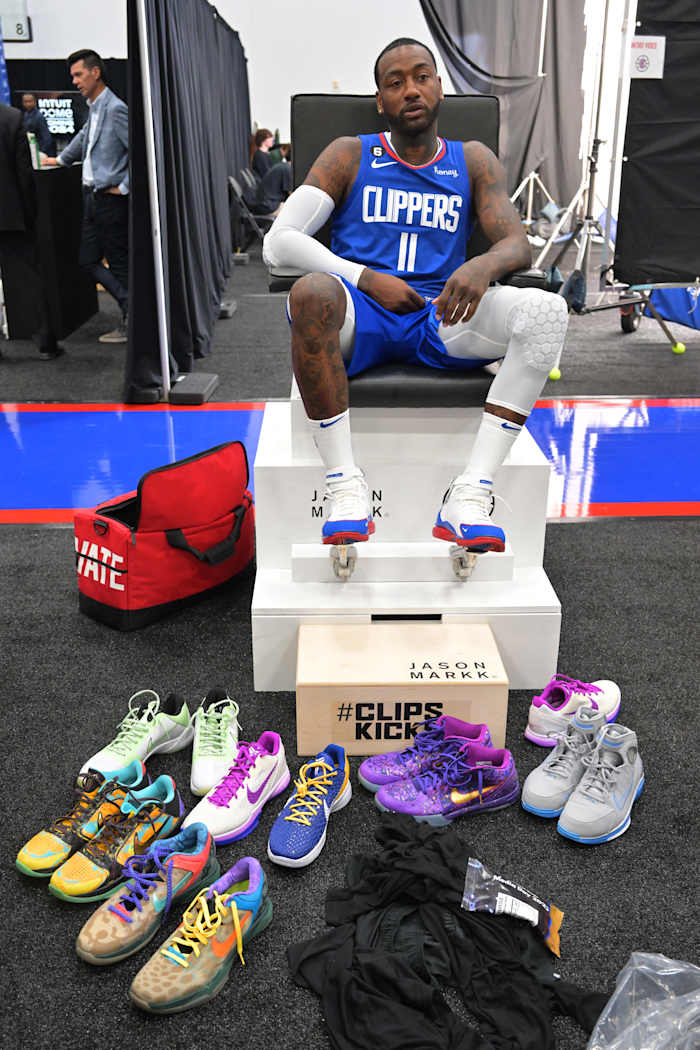 John Wall sits in front of sneaker collection.