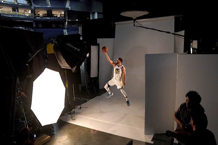 Stephen Curry jumps in the air for a photo shoot.