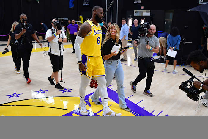 LeBron James walks and talks with a media member.