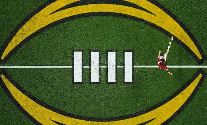 A player warms up on the College Football Playoff logo