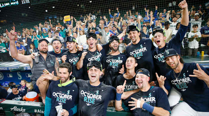 Sep 30, 2022; Seattle, Washington, USA; Seattle Mariners players and staff, including relief pitcher Matthew Boyd (first row, second from left) and catcher Cal Raleigh (first row second from right) celebrate in the dugout following a 2-1 victory against the Oakland Athletics to clinch a wild card playoff berth at T-Mobile Park.