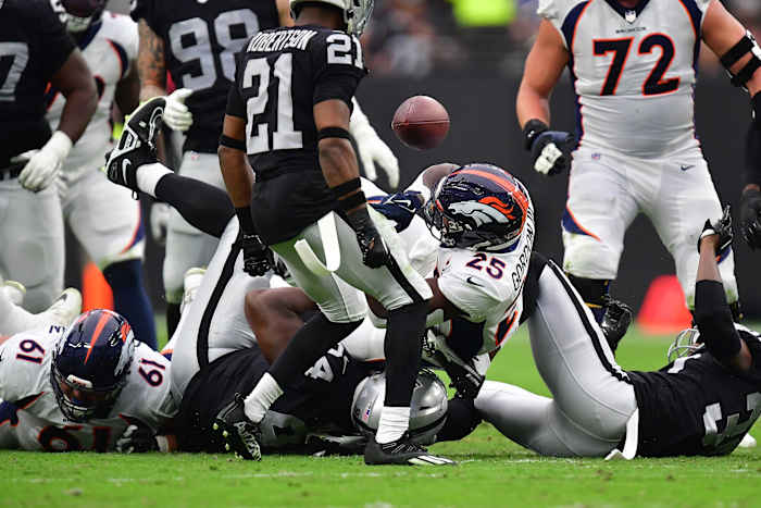 Denver Broncos running back Melvin Gordon III (25) loses the ball against the Las Vegas Raiders during the first half at Allegiant Stadium.
