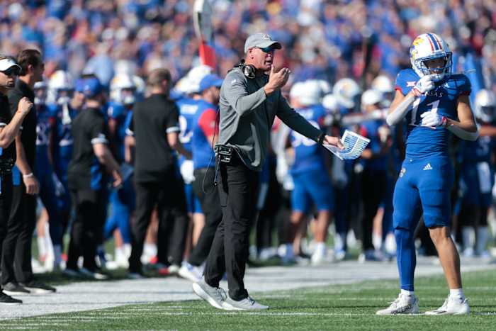 Kansas head coach Lance Leipold speaking to a player on the sideline.