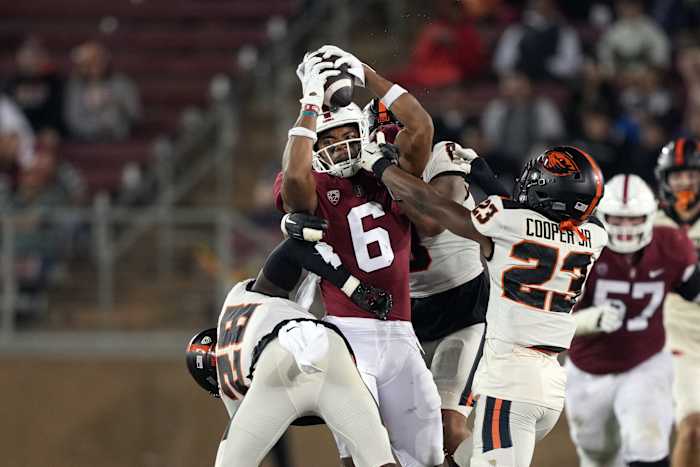 Stanford Cardinal wide receiver Elijah Higgins (6) holds onto a pass against Oregon State Beavers defensive backs Kitan Oladapo (28) and Ryan Cooper Jr. (23) during the second quarter at Stanford Stadium.