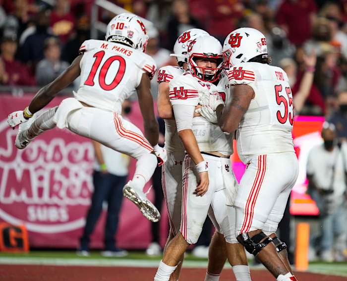 Utah Utes quarterback Cameron Rising (7) celebrates scoring a third quarter touchdown with wide receiver Money Parks (10) and offensive lineman Nick Ford (55) during the third quarter against the USC Trojans.