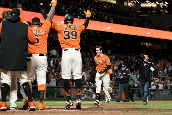 The SF Giants form a circle around home plate after Mike Yastrzemski's walk-off grand slam against the Brewers. (2022)