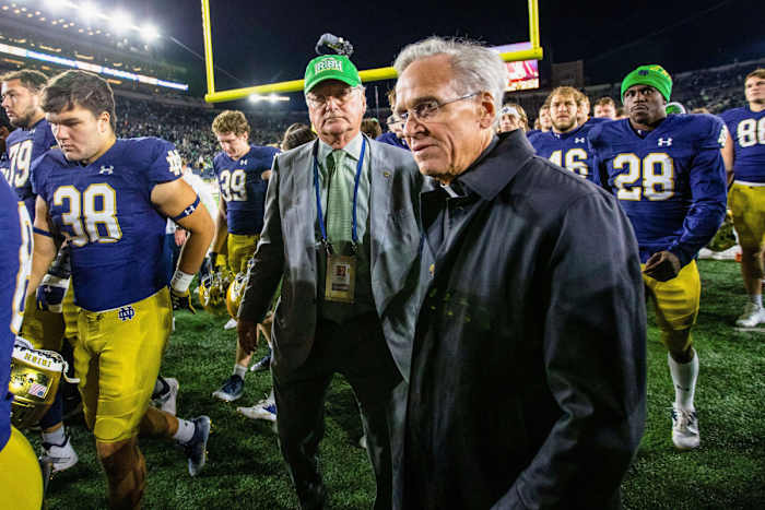 Notre Dame AD Jack Swarbrick and president John Jenkins with the football team after a game.