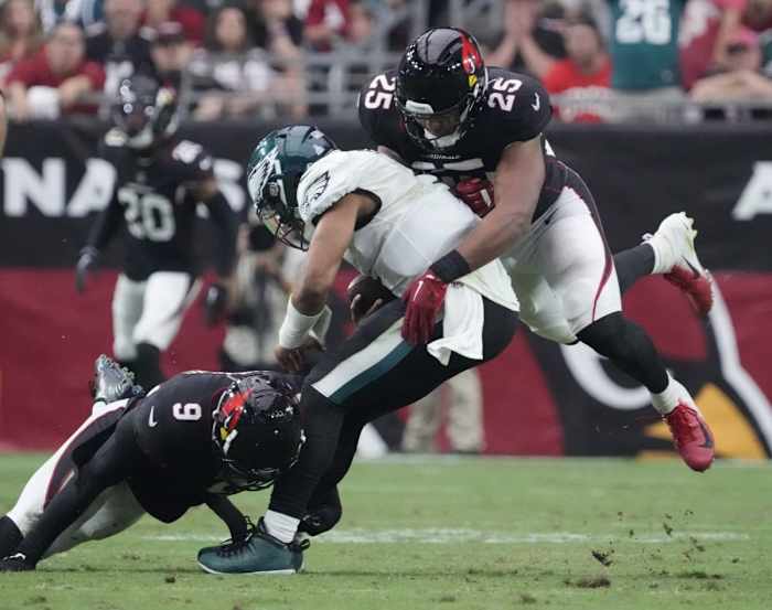 Philadelphia Eagles quarterback Jalen Hurts (1) is tackled by Arizona Cardinals linebackers Isaiah Simmons (9) and Zaven Collins (25). Mandatory Credit: Michael Chow-USA TODAY Sports