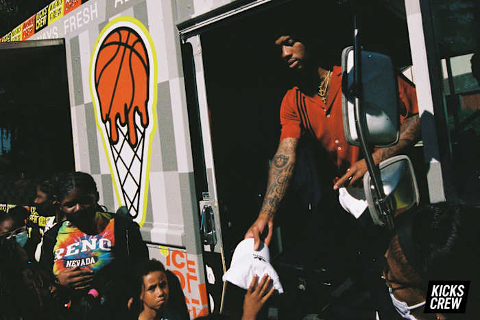 Damian Lillard hands shoes to kids.