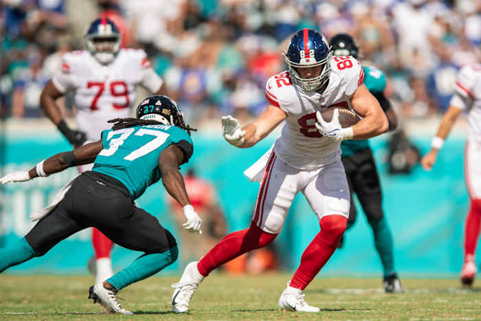 Oct 23, 2022; Jacksonville, Florida, USA; New York Giants tight end Daniel Bellinger (82) catches the ball against Jacksonville Jaguars cornerback Tre Herndon (37) in the second quarter at TIAA Bank Field.