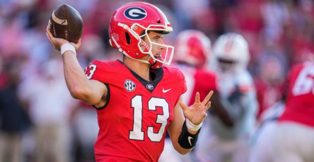 Georgia Bulldogs quarterback Stetson Bennett attempts a pass during a college football game in the SEC.